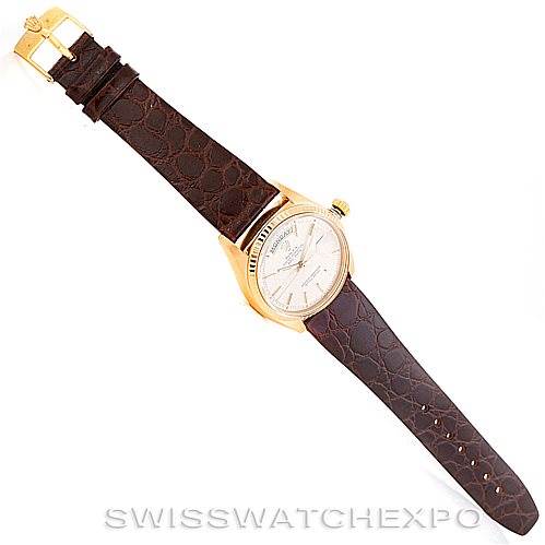 The image displays a Rolex President 1807 Men
s Yellow Gold Silver Dial 1807 Men
s Yellow Gold Silver Dial watch model laid flat, showing the dial, case, crown, and leather strap from a top view.