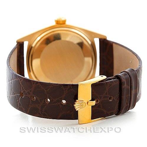 The Rolex President 1807 Men
s Yellow Gold Silver Dial 1807 Men
s Yellow Gold Silver Dial model watch is shown from the back, displaying the case back and brown leather strap with a gold buckle.