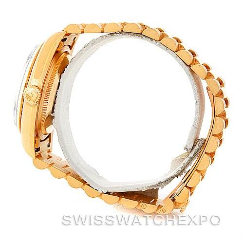 This side angle view of a Rolex President 18238 Men's Yellow Gold Blue Dial 18238 Men's Yellow Gold Blue Dial model watch displays its gold case, crown, and signature bracelet.