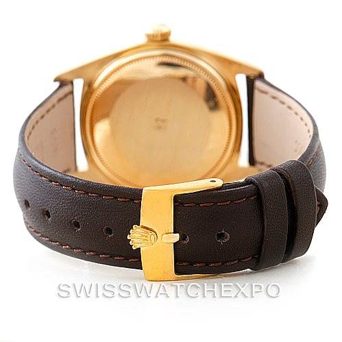 The image shows the back of a Rolex President 1803 Men
s Yellow Gold Champagne Dial 1803 Men
s Yellow Gold Champagne Dial model watch, focusing on its leather strap and gold buckle.