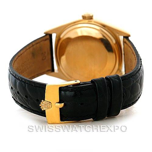 This image shows a rear view of the President model by Rolex, highlighting the golden case back and black leather strap with a golden buckle.