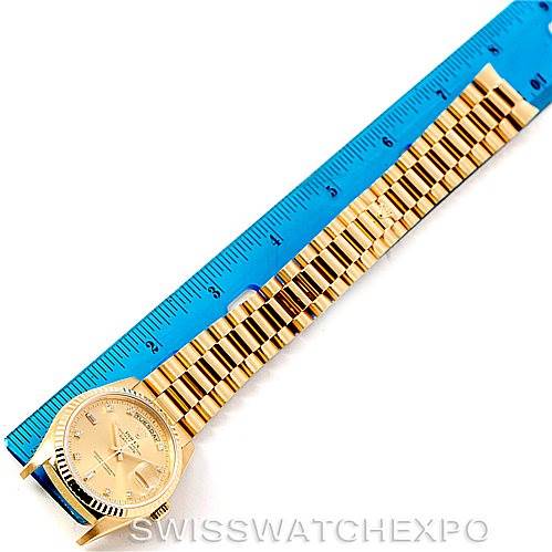 The image shows a gold Rolex President 18238 Men
s Yellow Gold Champagne Dial 18238 Men
s Yellow Gold Champagne Dial model watch laid flat next to a ruler, displaying its face and bracelet.