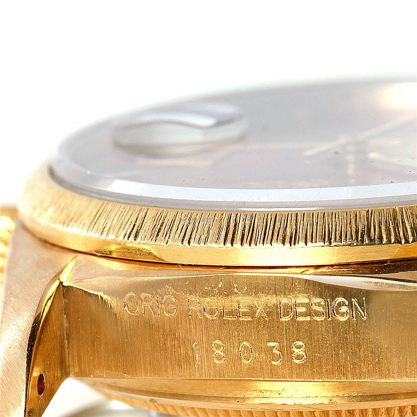 The image shows a close-up angled view of the side of a Rolex President 18038 Men
s Yellow Gold Brown Dial 18038 Men
s Yellow Gold Brown Dial model watch, highlighting the bezel and case with engraved text.