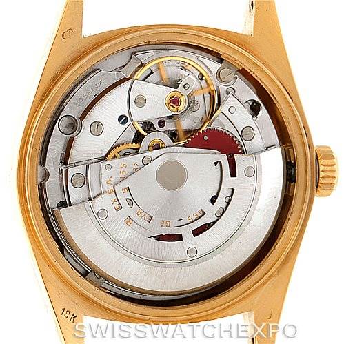 The image features a close-up, rear view of the Rolex President 18038 Men
s Yellow Gold Champagne Dial 18038 Men
s Yellow Gold Champagne Dial model, showcasing its internal mechanical movements.