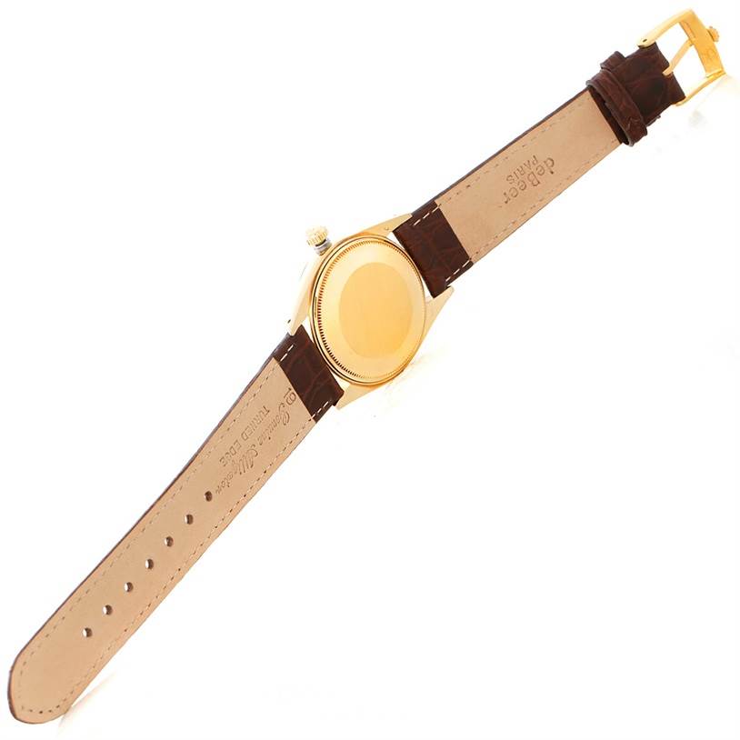 The image shows the back case and leather strap of a Rolex President 1503 Men
s Yellow Gold Champagne Dial 1503 Men
s Yellow Gold Champagne Dial model watch from a top-down angle.