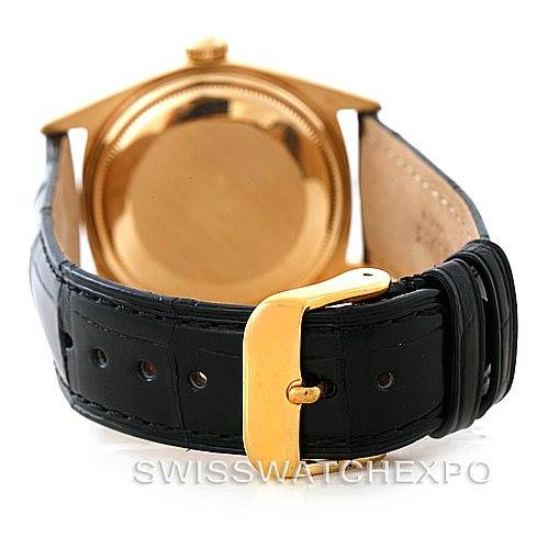 The image shows the back view of a Rolex President 1803 Men
s Yellow Gold Black Dial 1803 Men
s Yellow Gold Black Dial watch with a gold case and a black leather strap with a gold buckle.