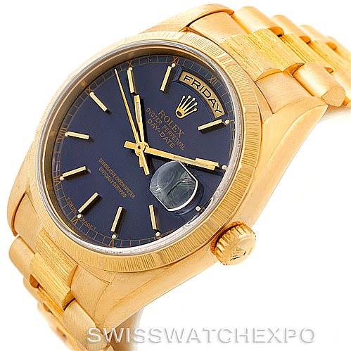 This image shows a close-up of the Rolex President 18248 Men's Yellow Gold Blue Dial 18248 Men's Yellow Gold Blue Dial model watch at a slight angle, highlighting the crown, bracelet, and the watch face with the day and date features.