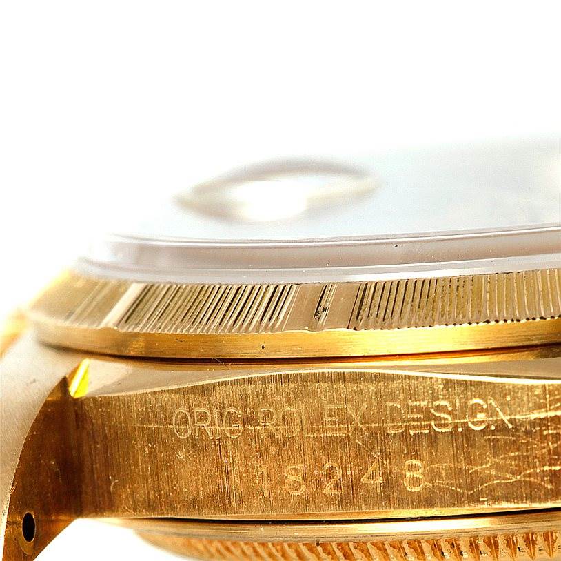 The image shows a close-up side angle of the Rolex President 18248 Men
s Yellow Gold Champagne Dial 18248 Men
s Yellow Gold Champagne Dial model, highlighting the bezel and part of the case with engravings.