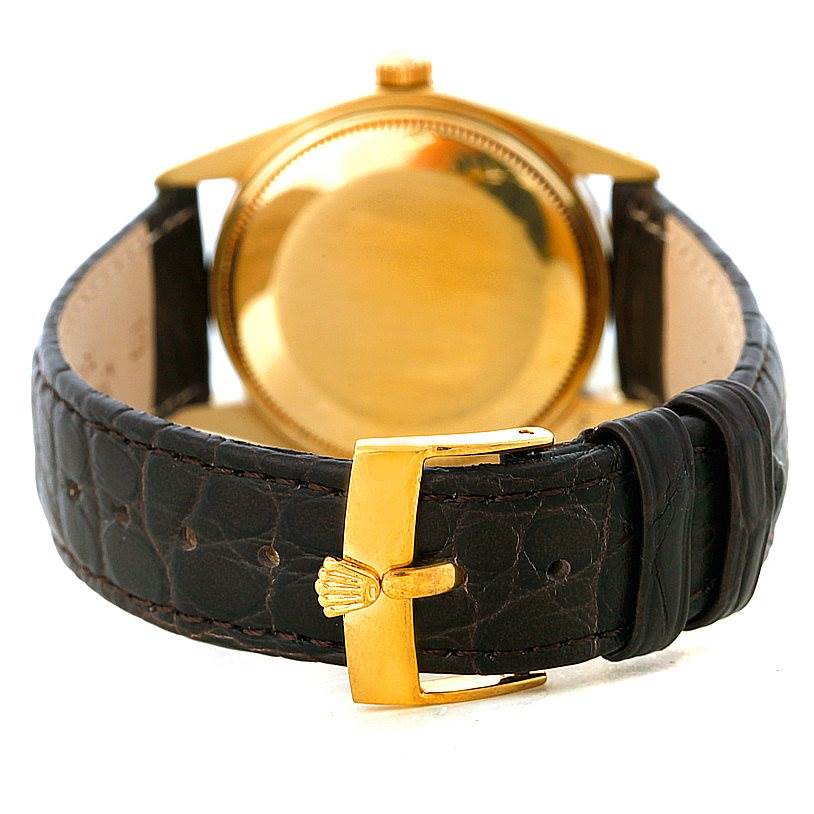 The image shows the backside of a Rolex President 1503 Men
s Yellow Gold Silver Dial 1503 Men
s Yellow Gold Silver Dial model watch, highlighting the case back, lugs, and leather strap with a gold clasp.