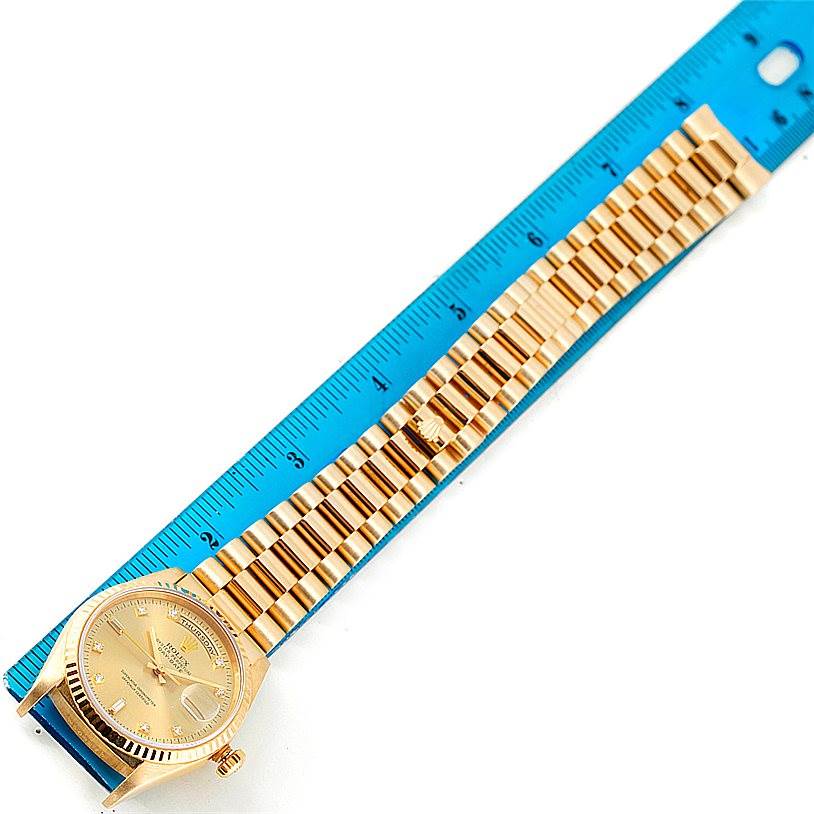 The image shows a Rolex President 18238 Men
s Yellow Gold Champagne Dial 18238 Men
s Yellow Gold Champagne Dial watch laid flat next to a blue ruler, displaying the face and full bracelet.