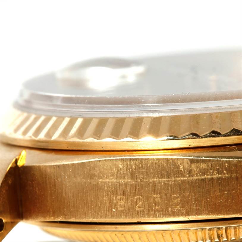 This image shows a close-up, side view of the Rolex President 18238 Men
s Yellow Gold Champagne Dial 18238 Men
s Yellow Gold Champagne Dial model watch, focusing on the bezel and case with engraved markings.