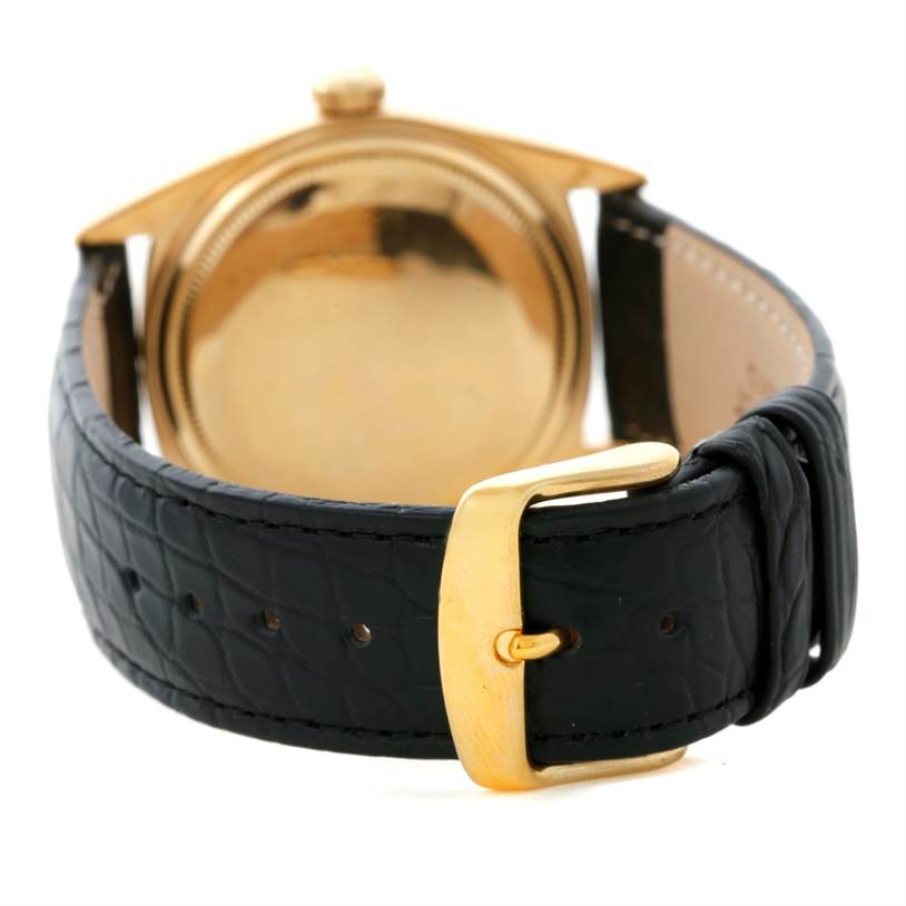 This image shows the back view of a Rolex President 1803 Men
s Yellow Gold Silver Dial 1803 Men
s Yellow Gold Silver Dial model watch with a black leather strap and a gold buckle.