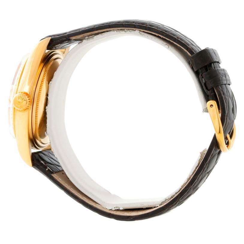 The Rolex President 1803 Men
s Yellow Gold Champagne Dial 1803 Men
s Yellow Gold Champagne Dial watch is shown from a side angle, highlighting its gold case, crown, and black leather strap with buckle.