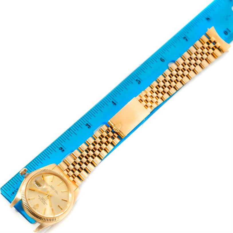 The image shows a Rolex President 1503 Men
s Yellow Gold Champagne Dial 1503 Men
s Yellow Gold Champagne Dial watch laid next to a ruler, highlighting its gold bracelet and face.