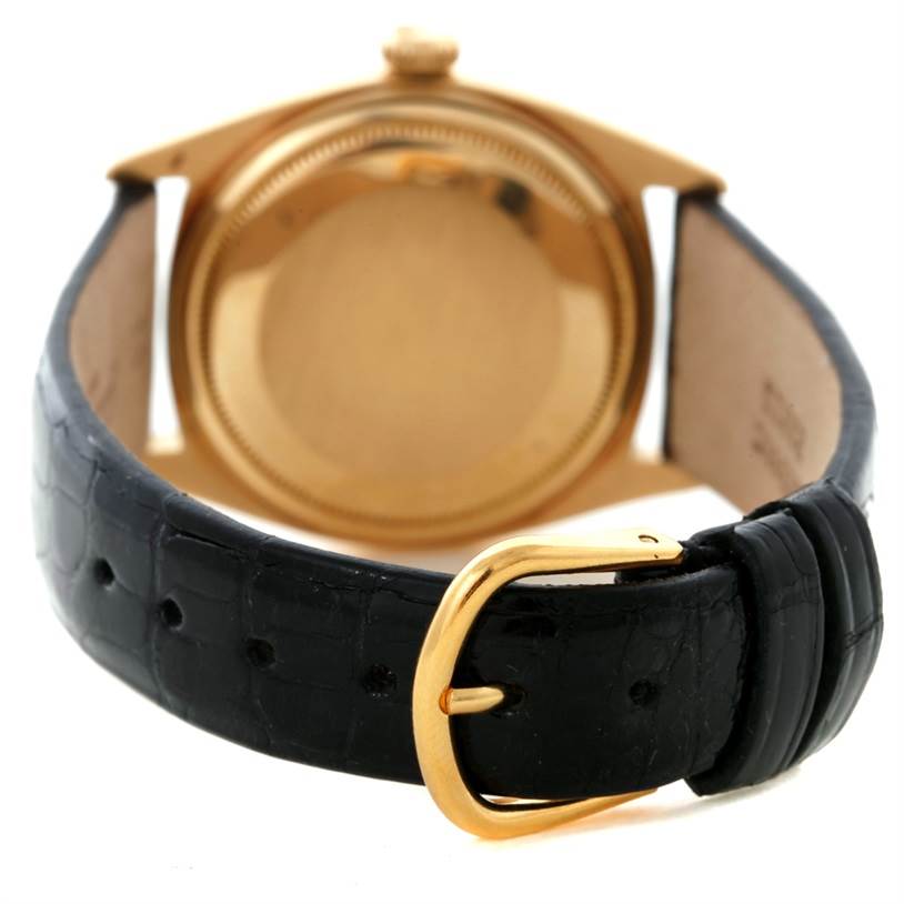 The image shows the back of a Rolex President 1601 Men's Yellow Gold White Dial 1601 Men's Yellow Gold White Dial model watch with a black leather strap and a gold buckle.