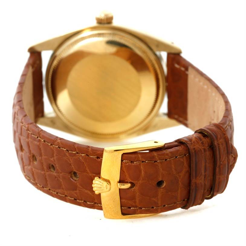 This image shows the back view of a Rolex President 1503 Men
s Yellow Gold Champagne Dial 1503 Men
s Yellow Gold Champagne Dial model watch, focusing on the case, crown, and leather strap with a gold clasp.