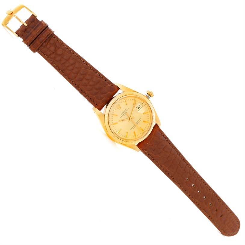 This is a Rolex President 1503 Men
s Yellow Gold Champagne Dial 1503 Men
s Yellow Gold Champagne Dial model watch shown from a top view, featuring its gold dial and brown leather strap.