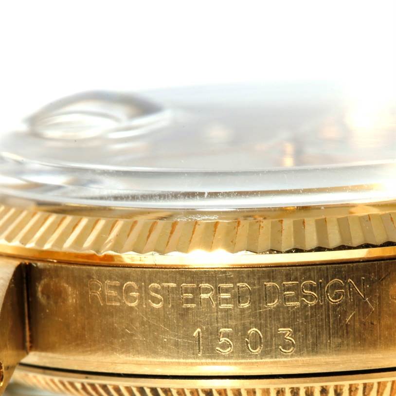 This close-up image of the Rolex President 1503 Men
s Yellow Gold Champagne Dial 1503 Men
s Yellow Gold Champagne Dial watch model focuses on the side view, highlighting the bezel and part of the case back with "Registered Design 1503."