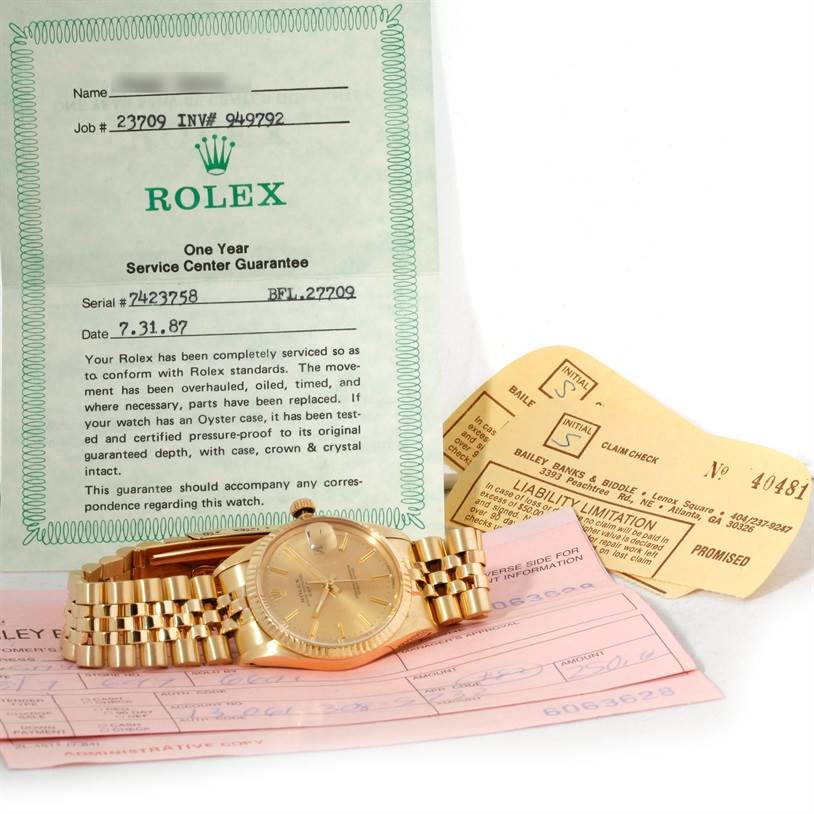 The image shows a Rolex President 15037 Men
s Yellow Gold Champagne Dial 15037 Men
s Yellow Gold Champagne Dial model watch placed at an angle with service documents and warranty cards.