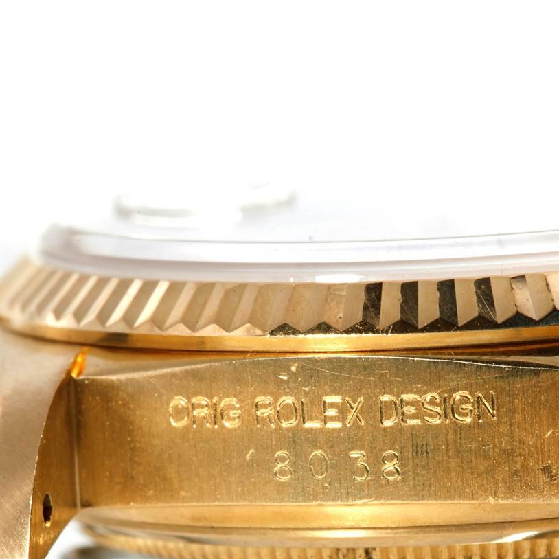 The image shows a close-up side view of a Rolex President 18038 Men
s Yellow Gold White Dial 18038 Men
s Yellow Gold White Dial model watch, focusing on the bezel and engraved case.
