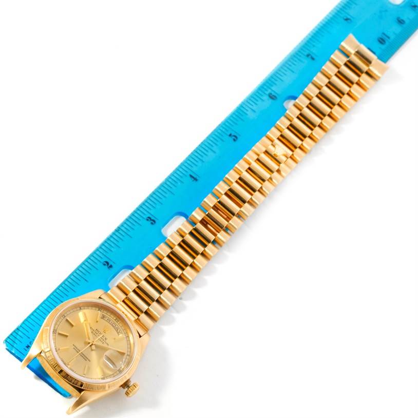 The image shows a top-down view of a Rolex President 18248 Men's Yellow Gold Champagne Dial 18248 Men's Yellow Gold Champagne Dial watch with its bracelet aligned next to a blue ruler for scale.