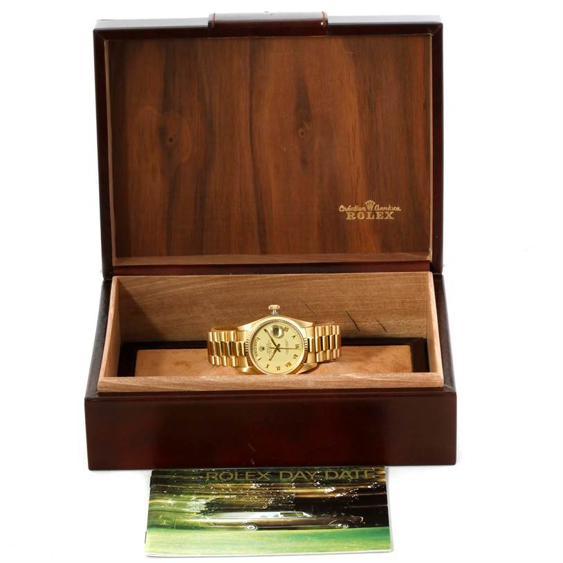 The Rolex President 18038 Men
s Yellow Gold Champagne Dial 18038 Men
s Yellow Gold Champagne Dial model watch is displayed in its open wooden box with a brochure in front.