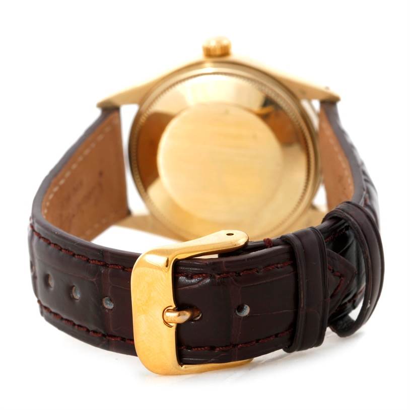 The image shows the back of a Rolex President 1503 Men
s Yellow Gold Silver Dial 1503 Men
s Yellow Gold Silver Dial watch, focusing on its case, crown, and leather strap with a gold buckle.