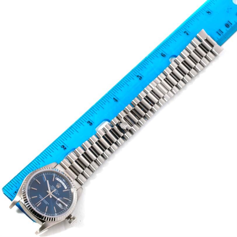The image shows a Rolex President 18239 Men's White Gold Blue Dial 18239 Men's White Gold Blue Dial model watch laid flat alongside a blue ruler, displaying its face and metal bracelet.