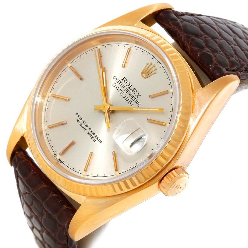 The Rolex President 16018 Men
s Yellow Gold Silver Dial 16018 Men
s Yellow Gold Silver Dial model watch is displayed at an angle showcasing the dial, crown, and part of the leather strap.