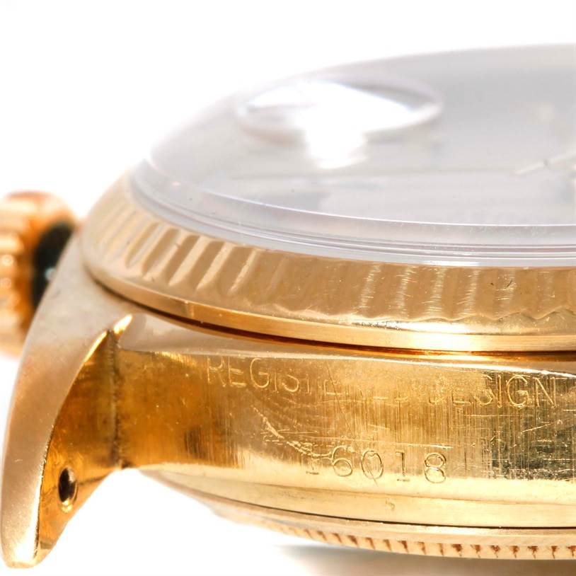 The image shows a close-up side view of a Rolex President 16018 Men
s Yellow Gold Silver Dial 16018 Men
s Yellow Gold Silver Dial model watch, highlighting the bezel, crown, and case with the model number engraved.