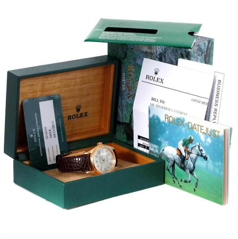 The image shows a Rolex President 16018 Men
s Yellow Gold Silver Dial 16018 Men
s Yellow Gold Silver Dial model watch in its box, along with papers, a warranty card, and a booklet.