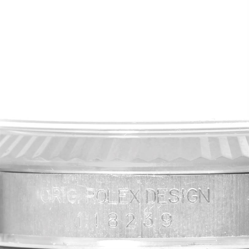 The image shows a close-up of the engraved serial number on the side of a Rolex President 118239 Men's White Gold Grey Dial 118239 Men's White Gold Grey Dial watch case.