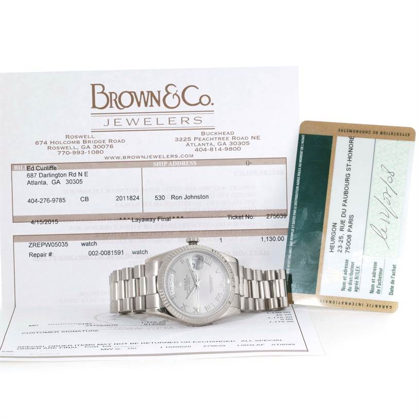 The Rolex President 118239 Men's White Gold Grey Dial 118239 Men's White Gold Grey Dial model watch is shown lying flat, accompanied by its paperwork and warranty card.