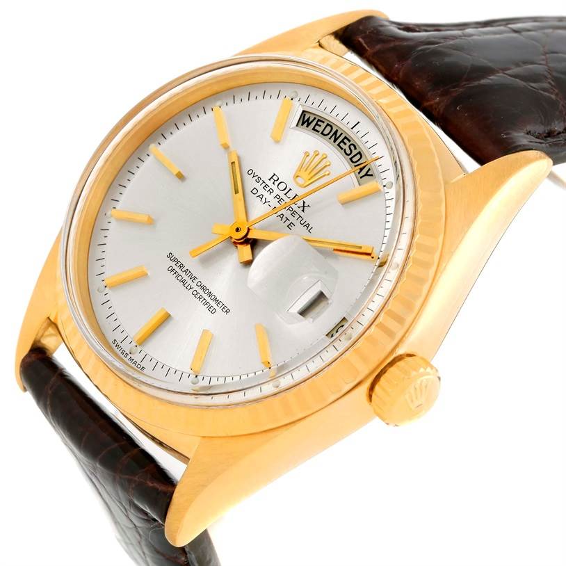The image shows an angled close-up view of a Rolex President 1803 Men
s Yellow Gold Silver Dial 1803 Men
s Yellow Gold Silver Dial model watch, focusing on the face, crown, and part of the leather strap.
