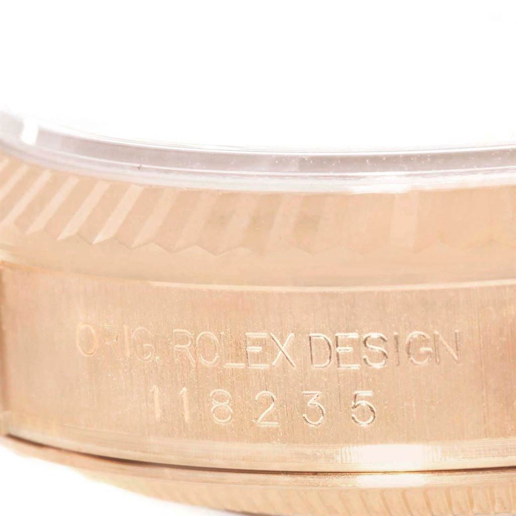 The image shows a close-up of the case side and bezel of a Rolex President 118235 Men's Rose Gold White Dial 118235 Men's Rose Gold White Dial model watch, displaying the engraved "ROLEX DESIGN" and model number.