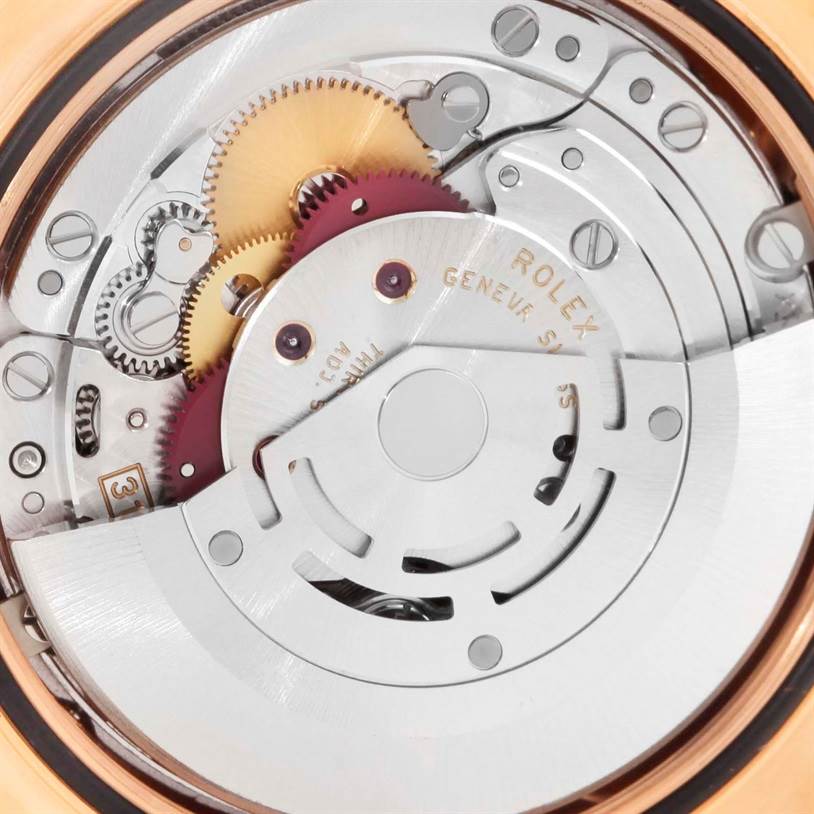 The image shows the intricate internal mechanism of a Rolex President 118205 Men's Rose Gold Black Dial 118205 Men's Rose Gold Black Dial model watch, focusing on gears and engravings.