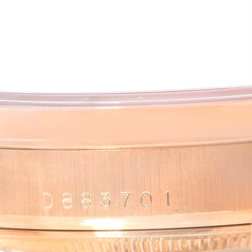 The image shows the side of a Rolex President 118205 Men's Rose Gold Black Dial 118205 Men's Rose Gold Black Dial model watch, focusing on its serial number engraved on the case.