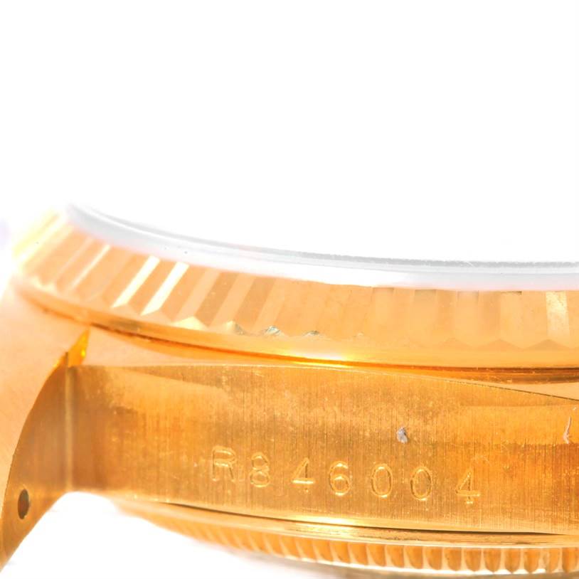 The image shows a close-up side angle of a Rolex President 18238 Men
s Yellow Gold Champagne Dial 18238 Men
s Yellow Gold Champagne Dial watch case, highlighting the gold fluted bezel and part of the serial number.