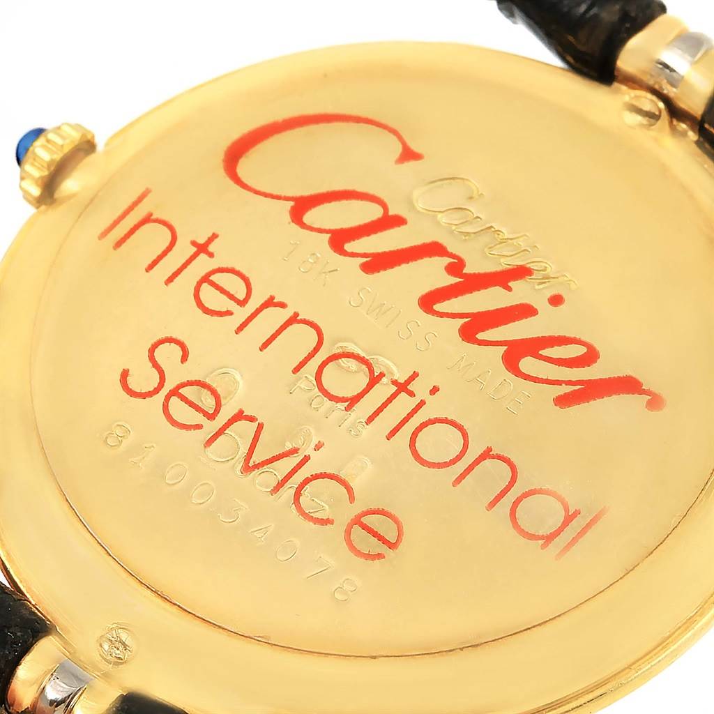 This is the back of the Trinity model watch by Cartier, showing inscriptions and the leather strap attachment.