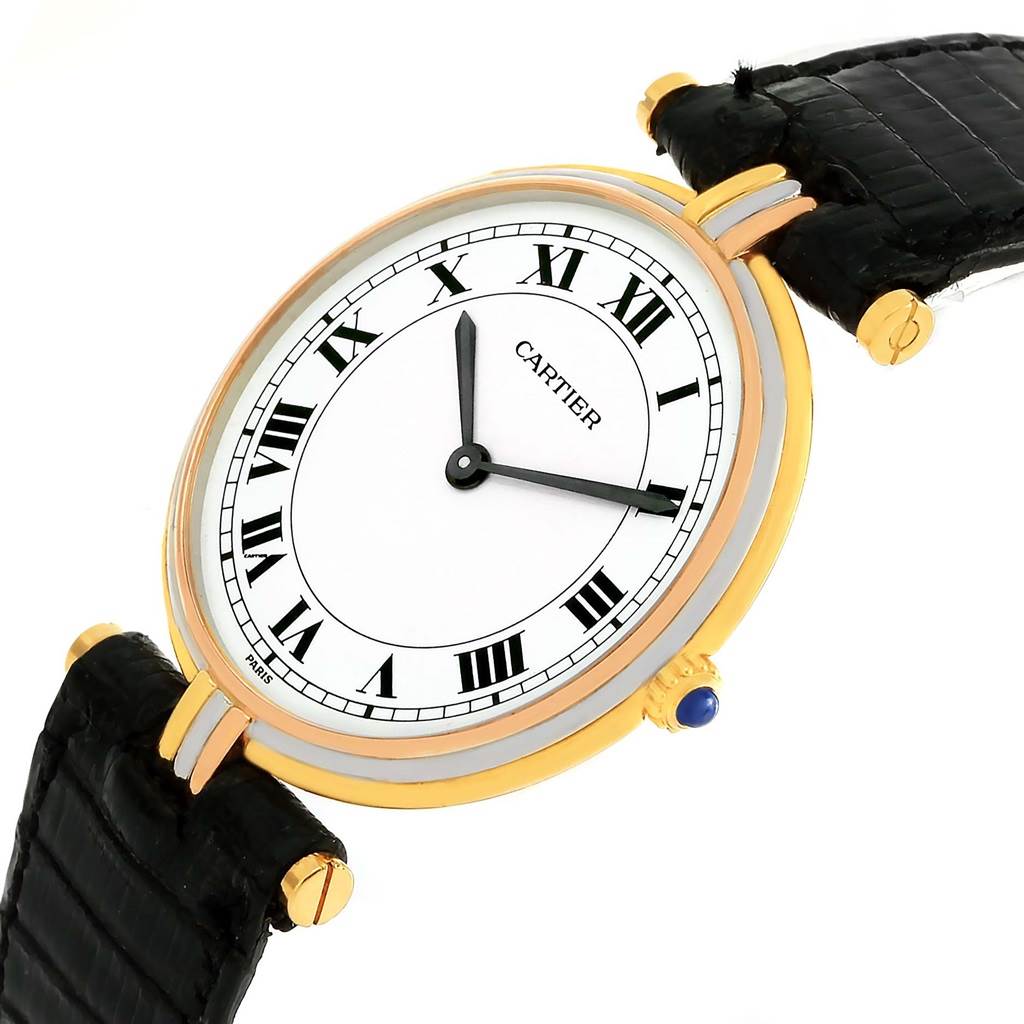 The image shows a Cartier Trinity W1514457 Yellow Gold White Dial W1514457 Yellow Gold White Dial model watch at an angled view, highlighting its face, Roman numerals, and black leather strap.