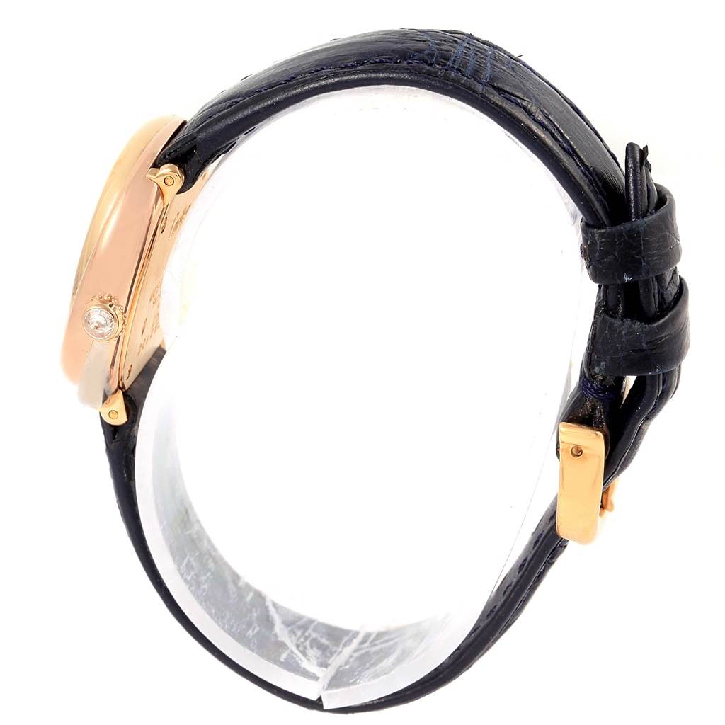 The image shows a side view of the Cartier Trinity W200246 Women's Yellow Gold Beige Dial W200246 Women's Yellow Gold Beige Dial model watch, highlighting its gold case, black strap, and a gemstone on the crown.