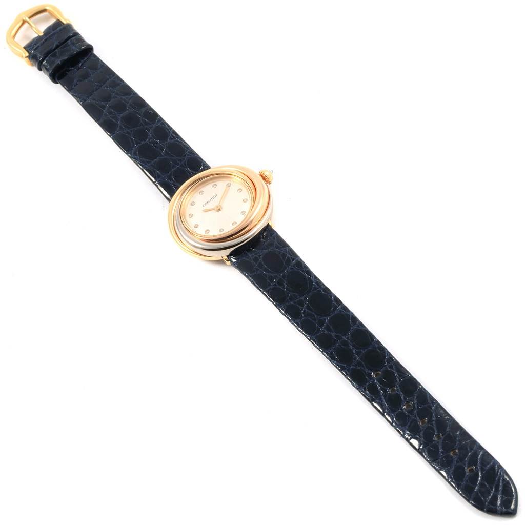 The Cartier Trinity W200246 Women
s Yellow Gold Beige Dial W200246 Women
s Yellow Gold Beige Dial model watch is shown from a top-down angle, displaying its dial, case, and entire black leather strap.