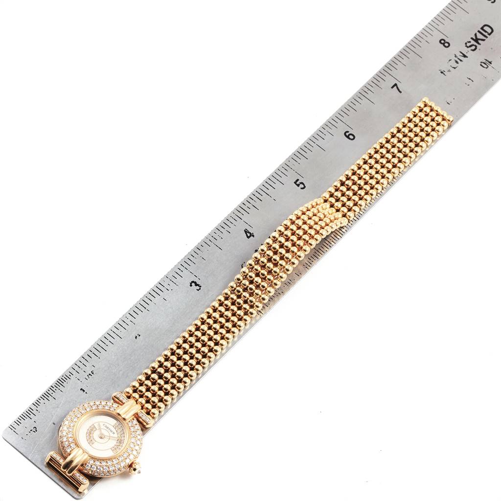 The image shows a Cartier Colisee  Women's Yellow Gold Silver Dial  Women's Yellow Gold Silver Dial watch laid flat alongside a ruler, showcasing its bracelet and face from a top view.