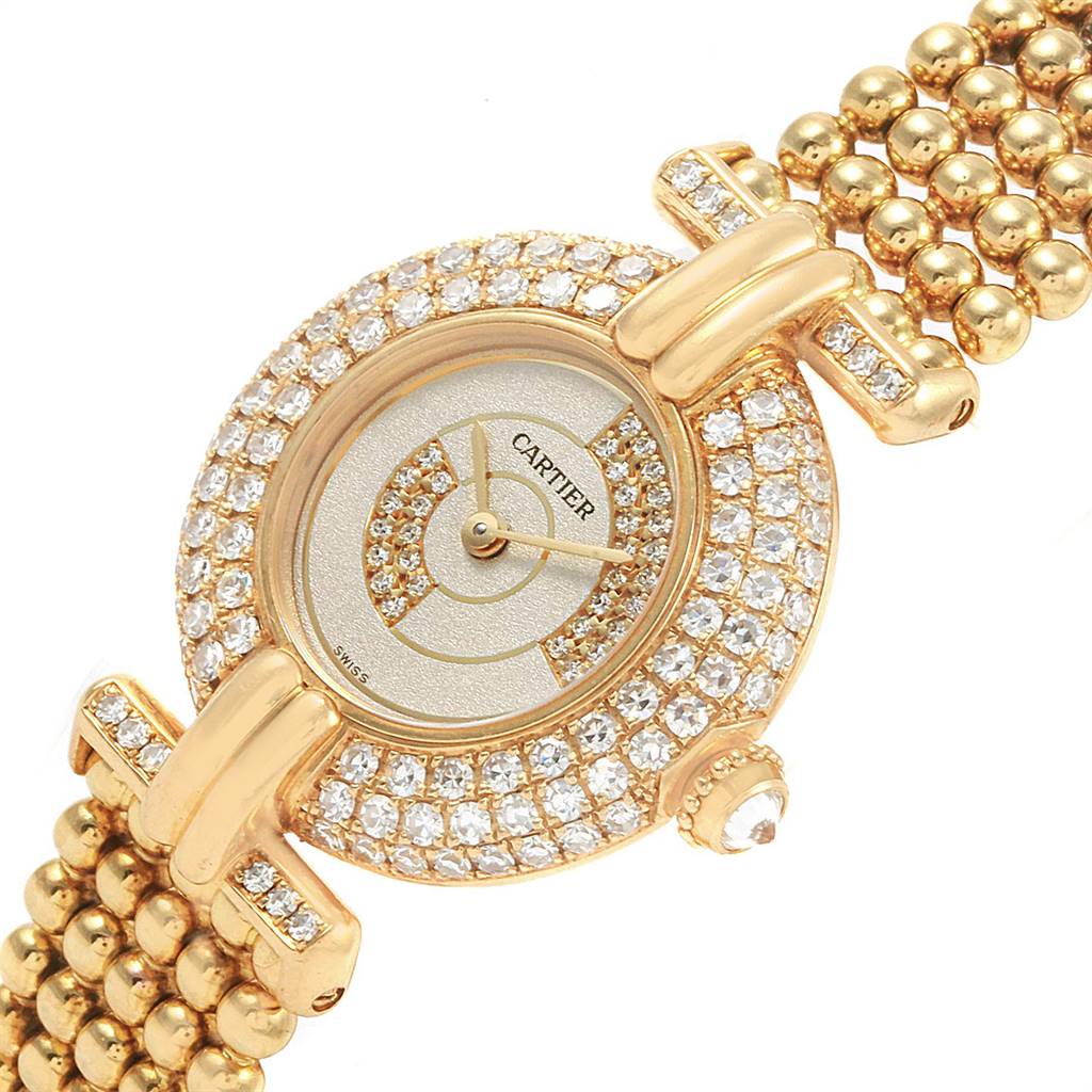 The image shows a Cartier Colisee  Women's Yellow Gold Silver Dial  Women's Yellow Gold Silver Dial watch face and part of the gold bead bracelet at an angled view.