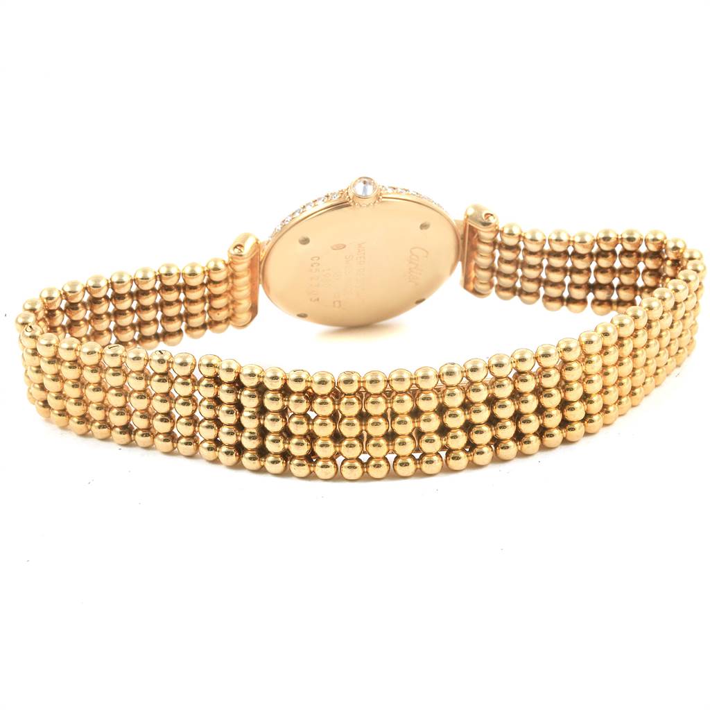 The image shows the back of a Colisee model by Cartier, emphasizing the gold bracelet and case back details.