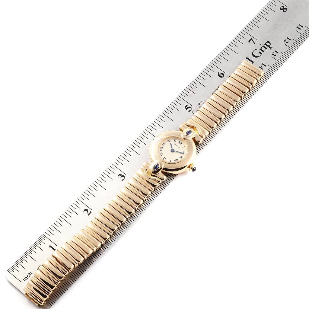 The Colisee model by Cartier is shown from a top-down angle on a ruler, highlighting the watch face and full band.