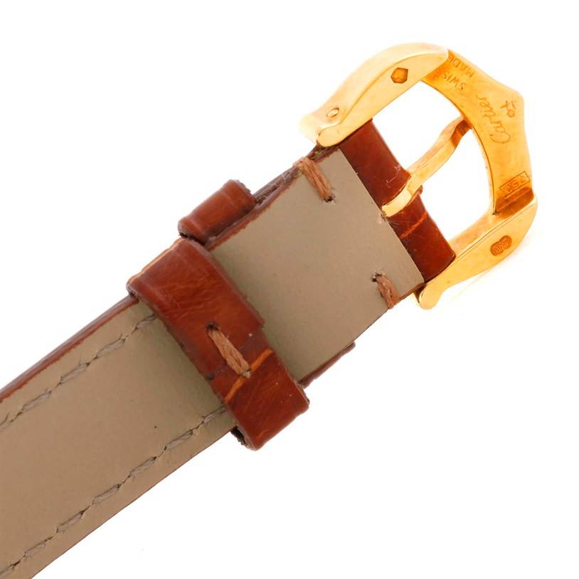 This image shows a close-up of the brown leather strap and gold buckle of a Colisee model watch by Cartier.