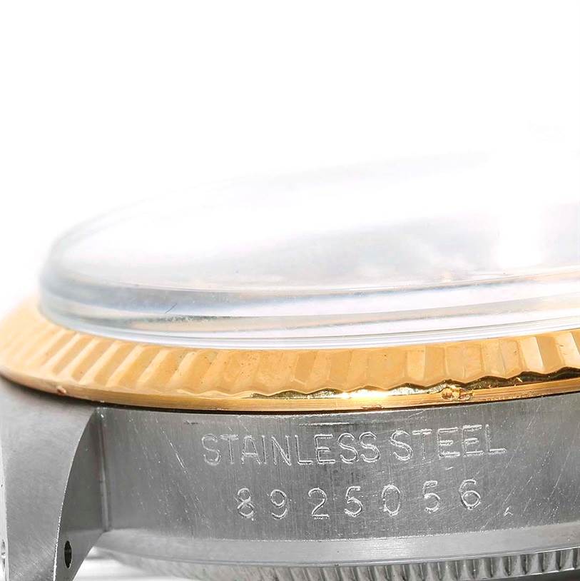 The image shows a close-up side view of the Rolex Datejust 16013 Men's Stainless Steel Champagne Dial 16013 Men's Stainless Steel Champagne Dial model's bezel, crystal, and stainless steel case engraved with a serial number.