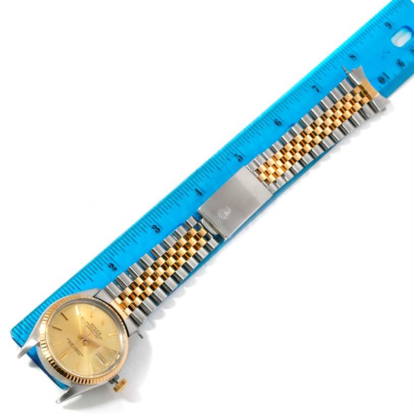 The image shows a Rolex Datejust 16013 Men's Stainless Steel Champagne Dial 16013 Men's Stainless Steel Champagne Dial watch laid next to a ruler, showcasing its face, crown, and metal bracelet.