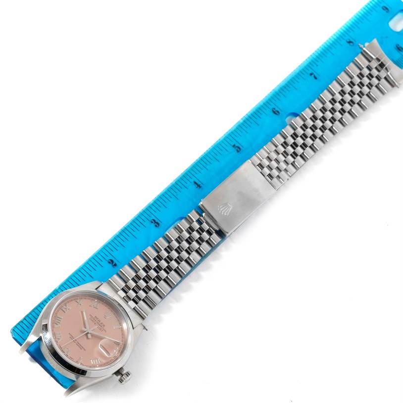 The image shows a Rolex Datejust 16200 Men
s Stainless Steel Pink Dial 16200 Men
s Stainless Steel Pink Dial watch laid flat next to a measuring ruler, displaying the face, bracelet, and clasp.